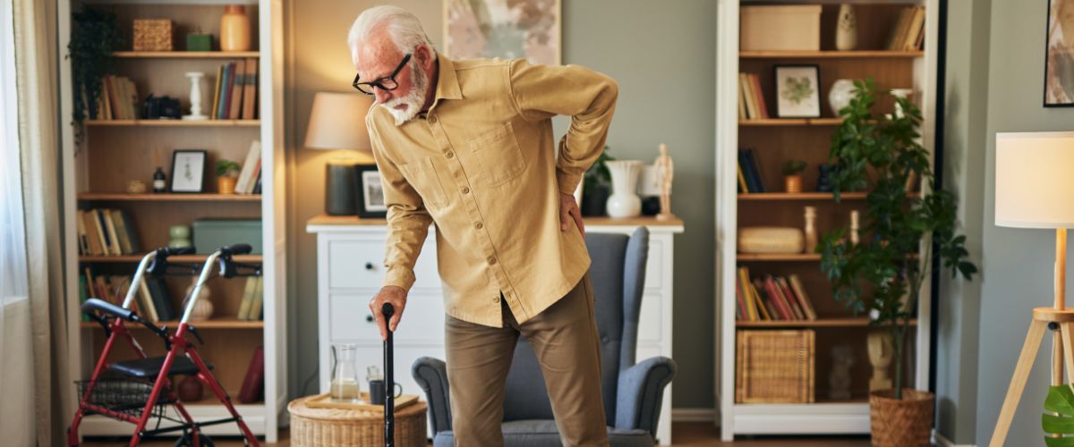 Elderly man with walking cane at home